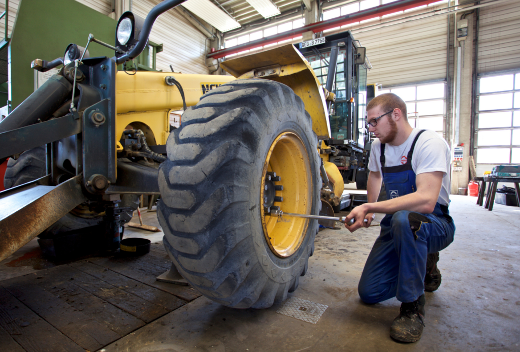 Auszubildender Land- und Maschinenbaumechatroniker am Traktor